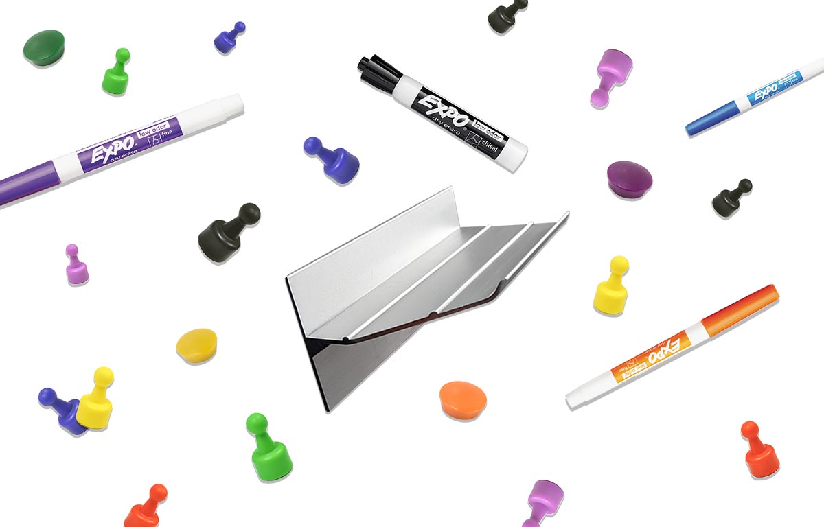 A rainbow of colorful magnets, dry erase markers and magnetic marker trays. 